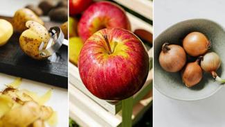 Sol tarafta, patates soyucu ile soyulan patatesler, ortada, ahşap bir kasada duran kırmızı ve sarı tonlarında bir elma, sağ tarafta bir kâsede üç adet kahverengi soğan var.